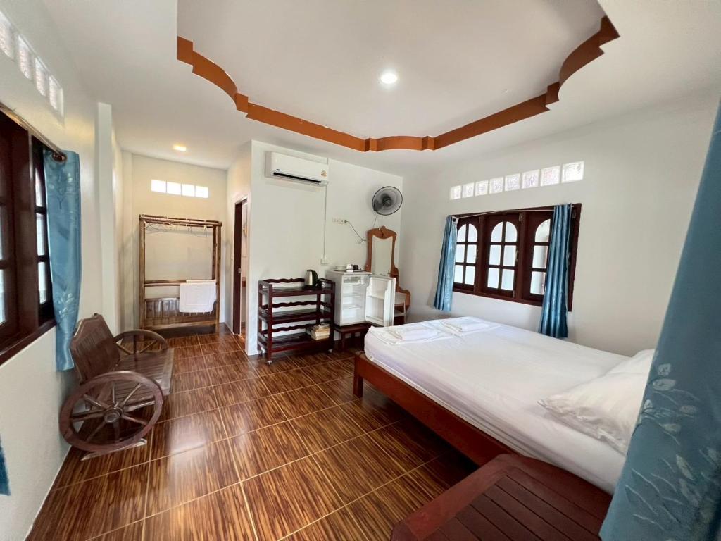 a bedroom with a bed and a desk in it at Silver Beach Bungalow in Haad Yao