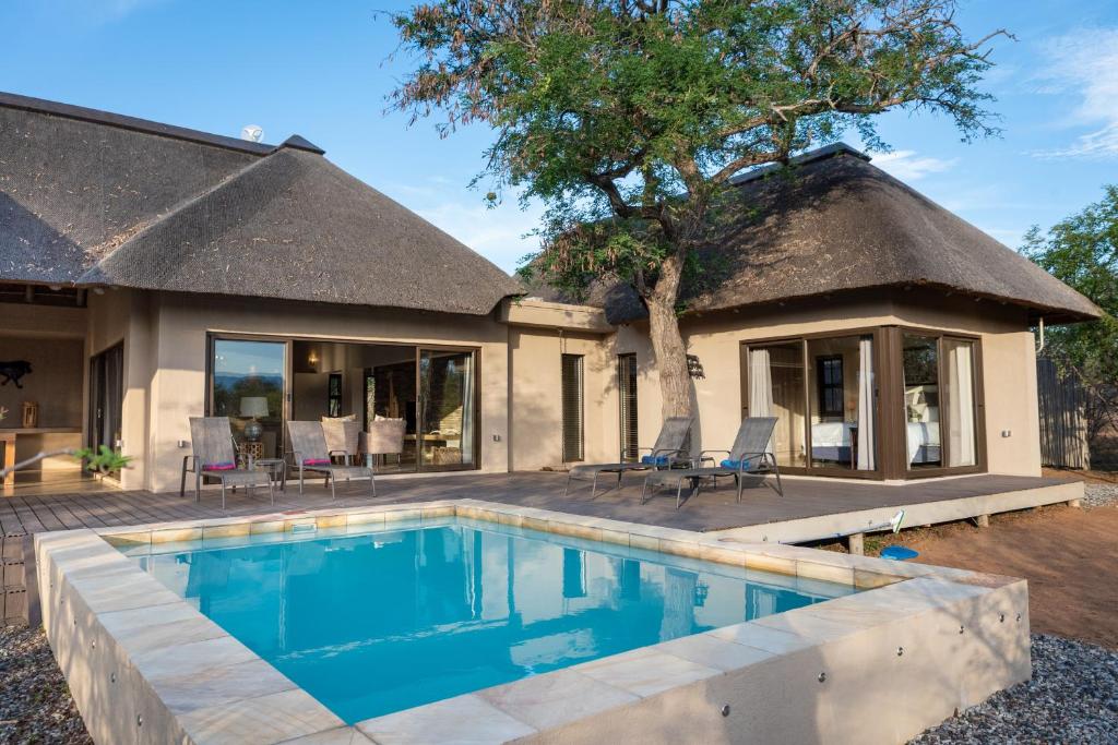 una casa con piscina delante de una casa en Villa Marula, en Hoedspruit