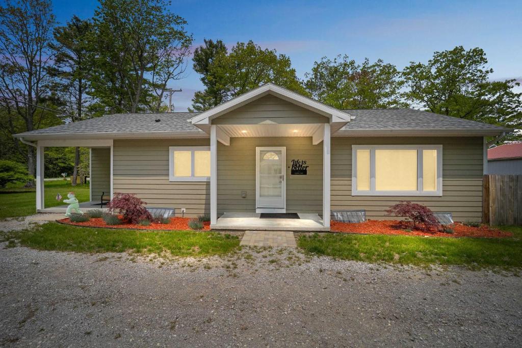 una piccola casa con portico e vialetto di Spacious 3BR Lakefront Cottage with Stunning Views a Lincoln Junction