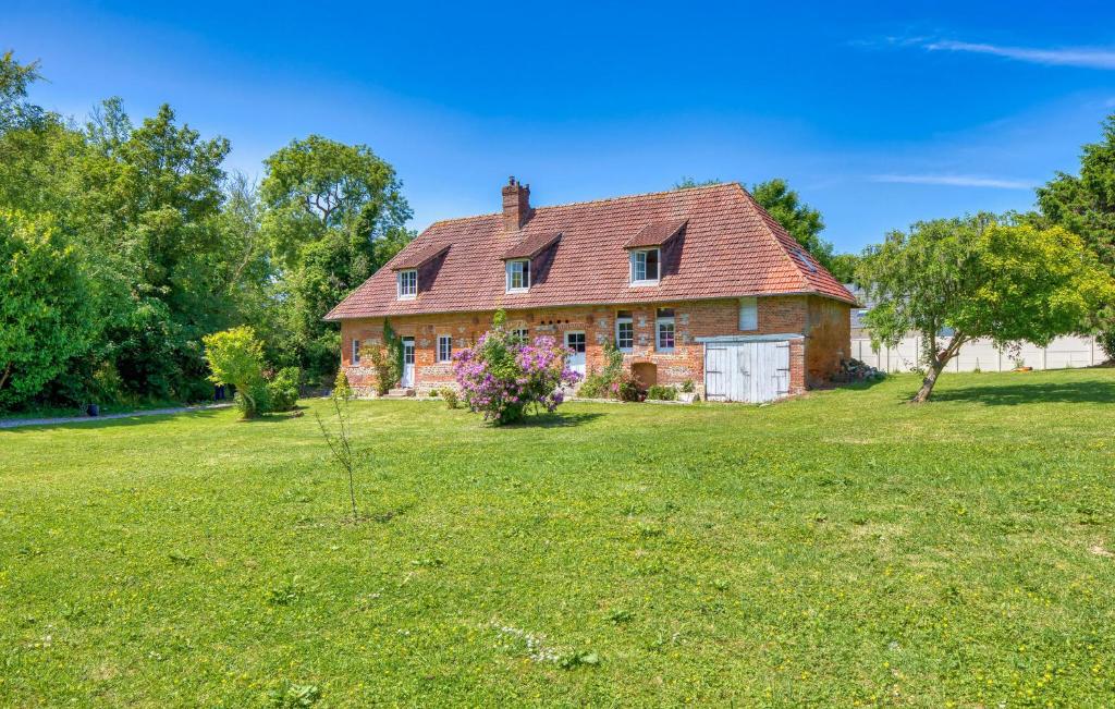 an old house in a field with a tree in the yard at Athentique Maison Normande in Vénesville