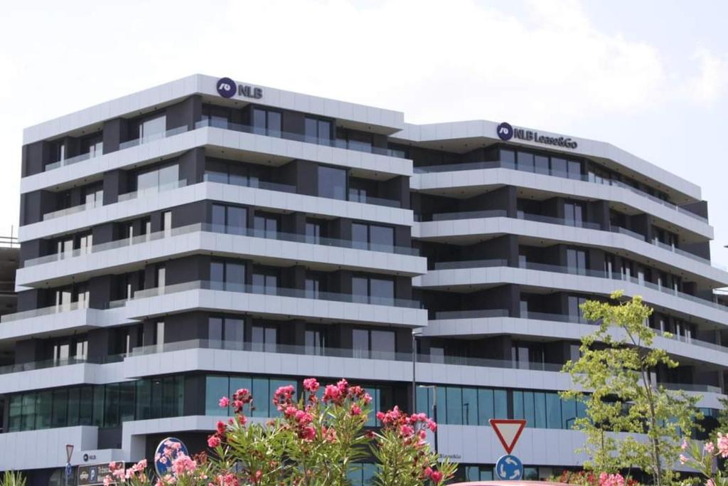 un immeuble de bureaux avec une enseigne au sommet dans l'établissement Mezenin Solis, à Koper