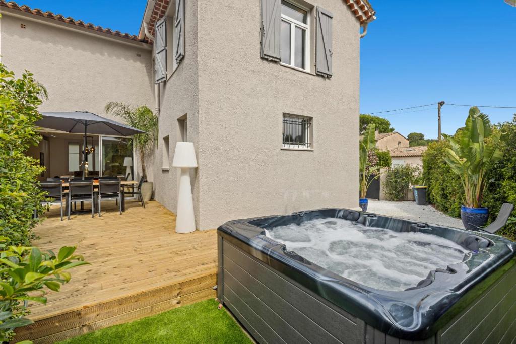 un bain à remous dans une cour avec une maison dans l'établissement Luxueuse Villa L'Olivier Cannes 4 chambres jacuzzi, à Cannes