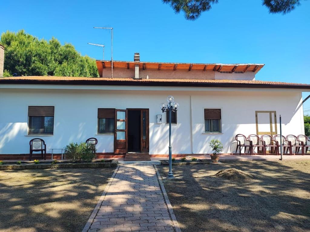 a white house with chairs in front of it at Casetta STELLA MARINA PUNTA SABBIONI in Cavallino-Treporti