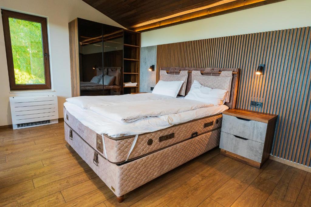 una cama grande en una habitación con ventana en Pristan in the mountain luxury suits, en Shilkovtsi