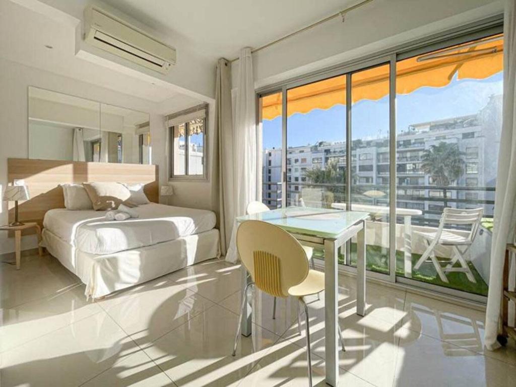 - une chambre avec un lit, une table et un balcon dans l'établissement Le ROUAZE studio - proche Carlton et Martinez - idéal congrès - Wifi Clim, à Cannes