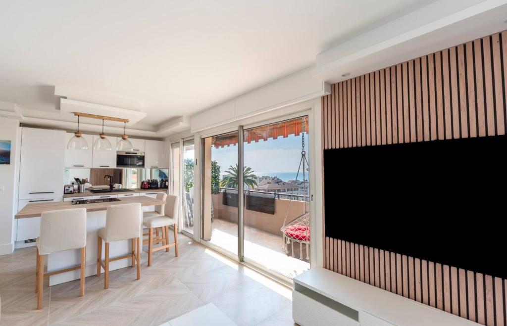 Il dispose d'une cuisine et d'un salon avec une télévision à grand écran. dans l'établissement Les YUCCAS - 2 pièces Suquet Parking Vue Mer pour 4 personnes, à Cannes