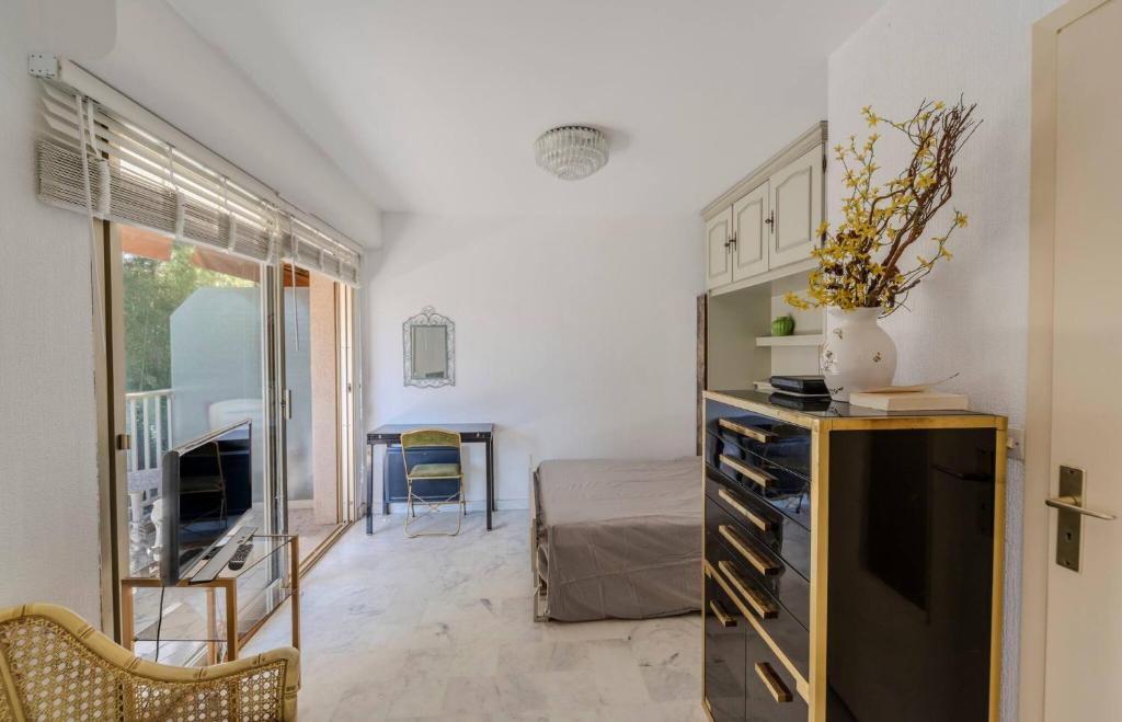 Cette chambre comprend une chambre avec un lit et une commode. dans l'établissement Studio Fenelon terrasse et Parking Cannes, à Cannes