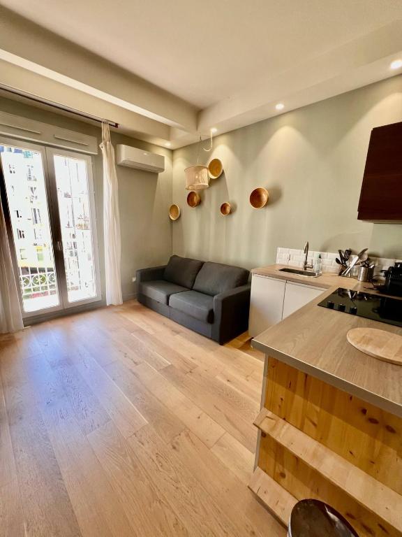un salon avec un canapé noir et une cuisine dans l'établissement Studio Nice Hyper-centre Jean Médecin, à Nice
