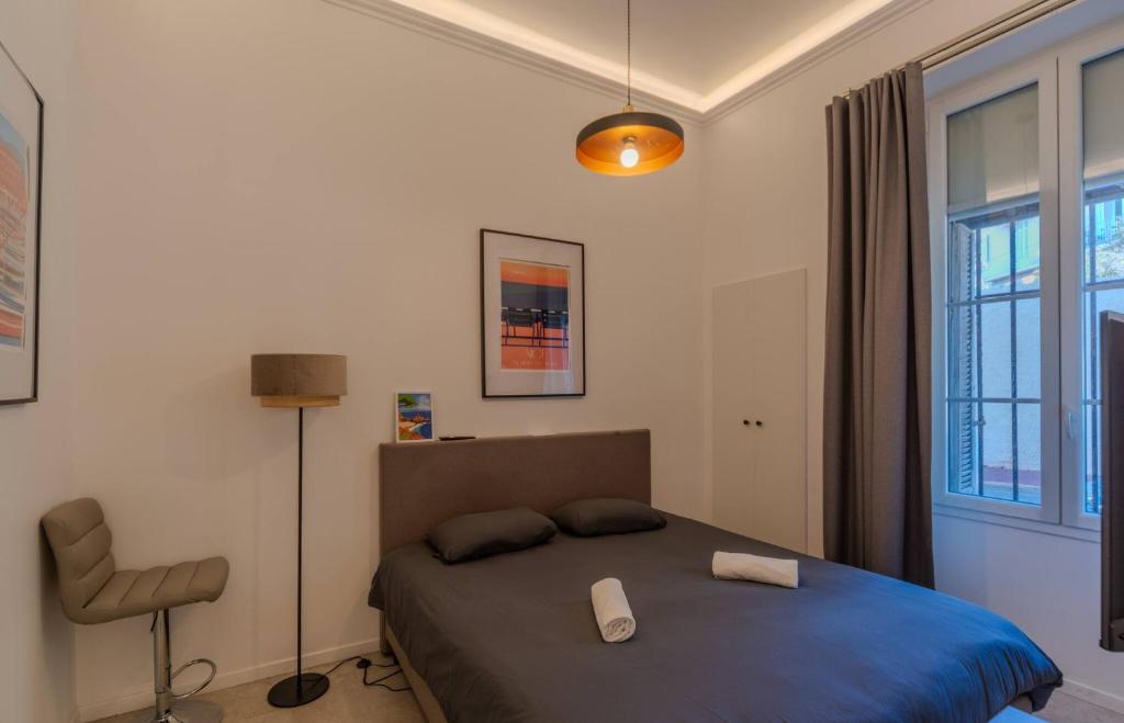 une chambre avec un lit et une chaise dedans dans l'établissement Le Lac Studio Moderne Proche Suquet - climatisation Wifi - LIMESTAY, à Cannes