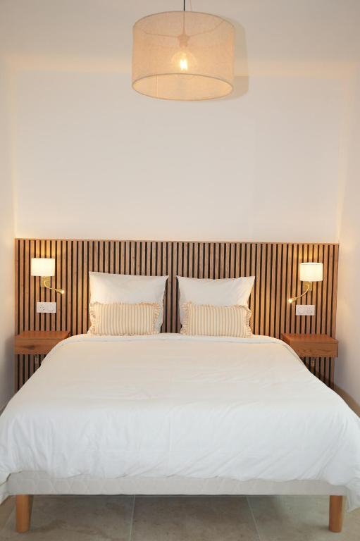 a bedroom with a large white bed with two pillows at La verrière in Avignon