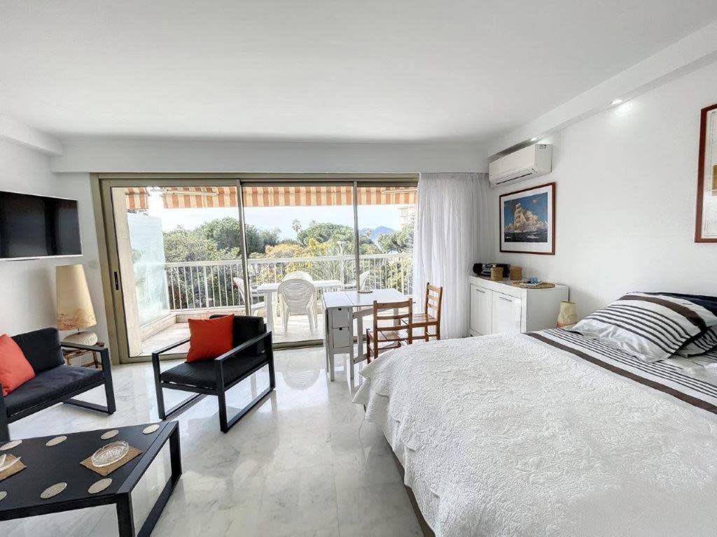 une chambre avec un lit, une table et des chaises dans l'établissement STUDIO MIDI MAGRET Cannes, à Cannes