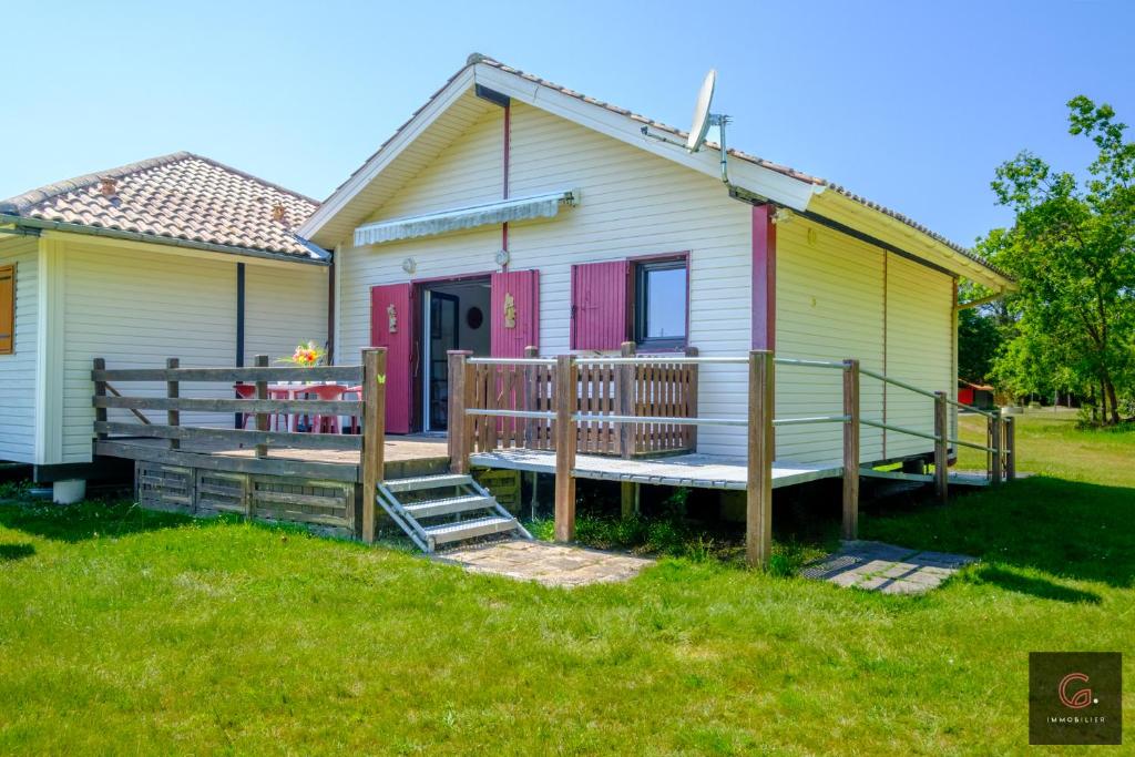 une petite maison avec un porche et une terrasse dans l'établissement Maison PMR à 5 min du lac de Sanguinet 4 personnes, à Sanguinet