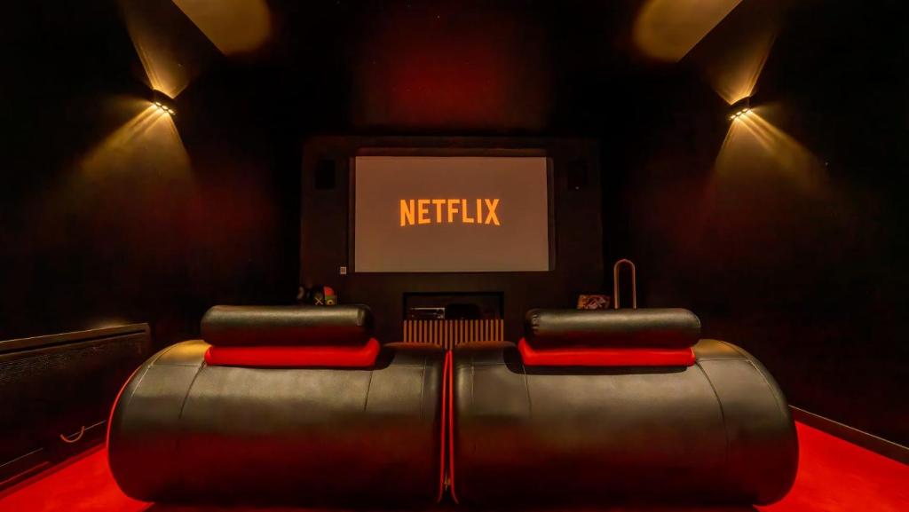 a room with a tv and a couch with avertisement at Cine47spa in Précy-sur-Oise