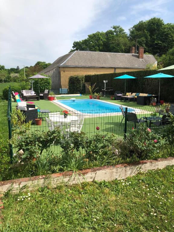 - une piscine dans une cour avec des chaises et des parasols dans l'établissement Petite Gaudiniere, à La Chapelle-Gauguin