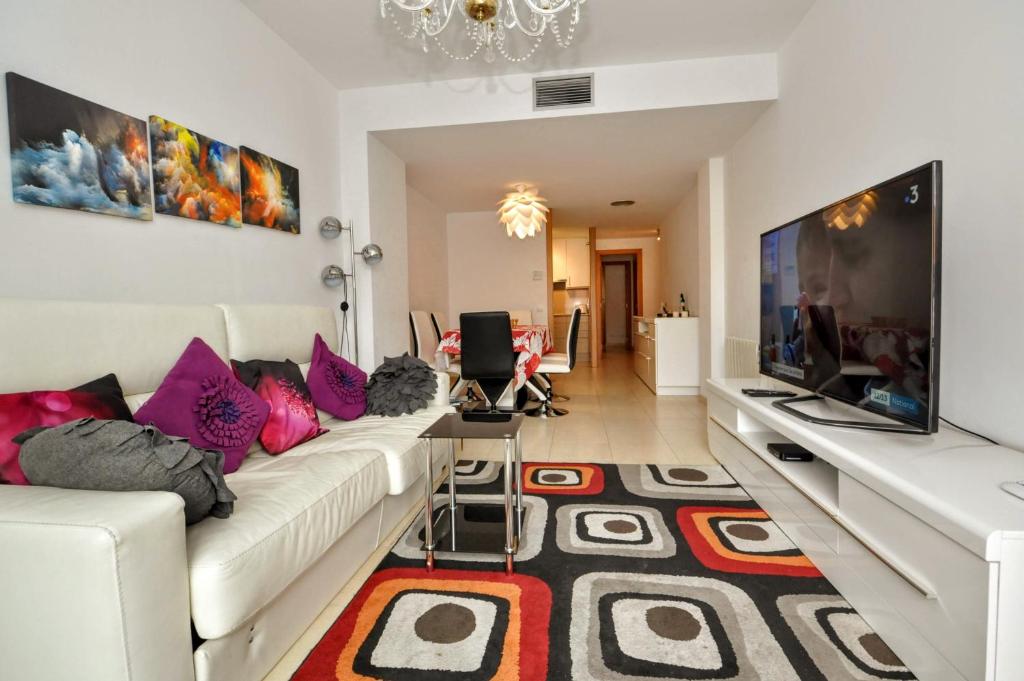 a living room with a white couch and a flat screen tv at Apartment Verano Go2lloret in Lloret de Mar