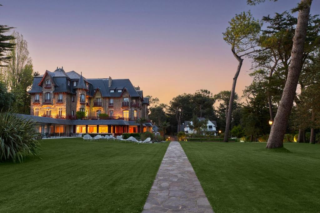 a large house with a lawn in front of it at Le Castel Marie Louise in La Baule