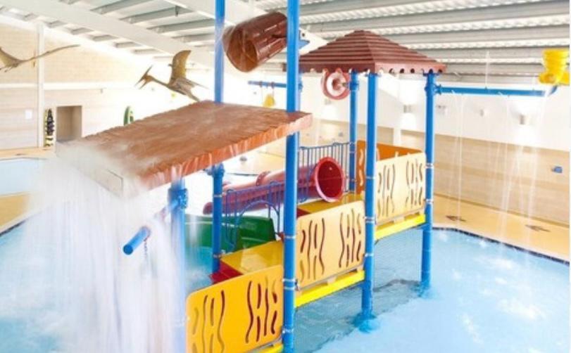 een zwembad met een waterpark met speelstructuur bij Ardmachree in Burton Bradstock