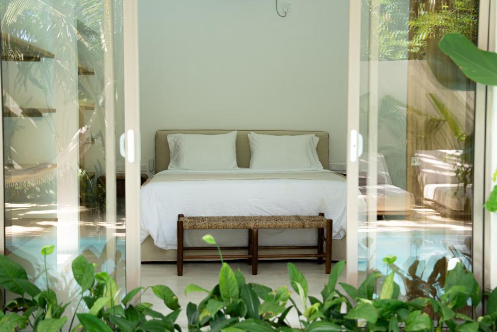 a bedroom with a bed and a table and plants at Villa Vera in Ahangama