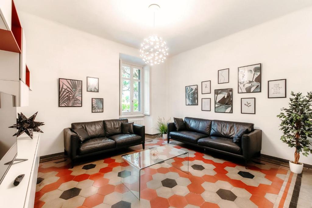 een woonkamer met 2 leren banken en een glazen tafel bij Cedro Apartment by Quokka 360 - designer flat in Como in Como