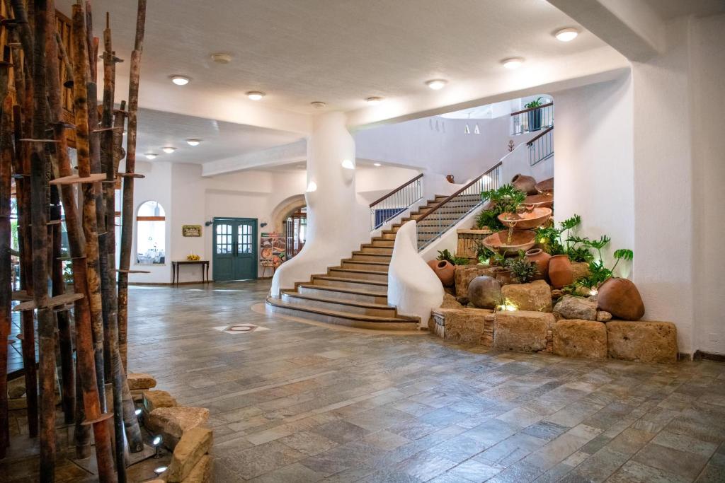 a lobby with a staircase with plants in it at Coral Beach Hotel & Resort Cyprus in Coral Bay