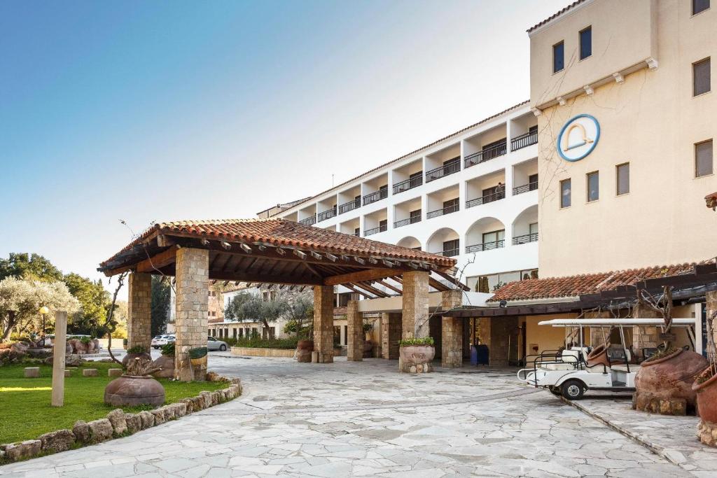 a hotel with a pavilion in front of a building at Coral Beach Hotel & Resort Cyprus in Coral Bay