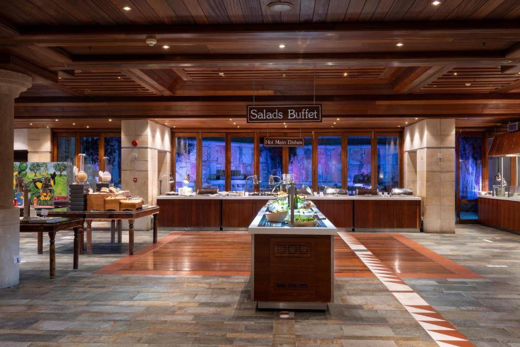 a lobby of a hotel with a buffet in the center at Coral Beach Hotel & Resort Cyprus in Coral Bay