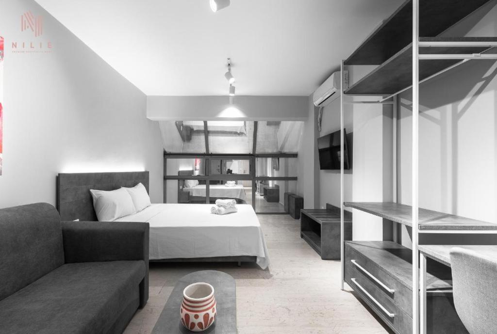 salon z łóżkiem i kanapą w obiekcie Modeco, Nilie Hospitality MGMT w Salonikach