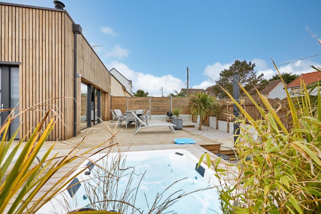 un cortile con piscina e una casa di La Bouteille à la Mer-Maison darchitecte jacuzzi a Barneville-Carteret