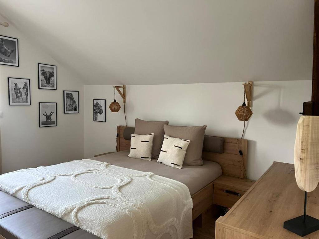a bedroom with a bed and a wooden table at La Maison Zanzibar in Lavilletertre