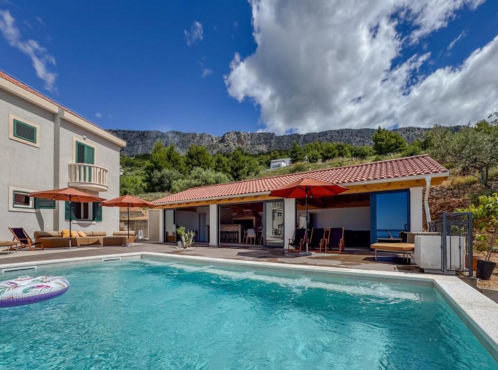 a swimming pool in front of a house at Villa Olive retreat in Krilo