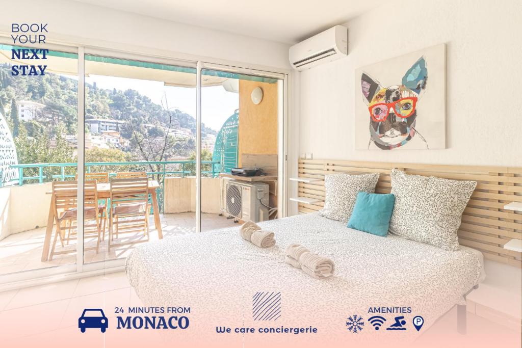 une chambre avec un lit et un balcon avec une table dans l'établissement Peaceful Studio Swimming Pool Near Menton, à Roquebrune-Cap-Martin