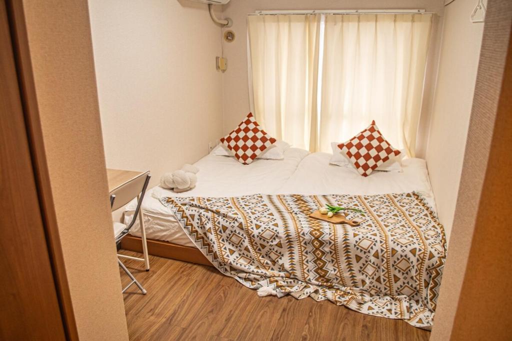 a small bedroom with a bed and a window at Near Shinjuku Nakano unit walking 4mins Broadway in Tokyo