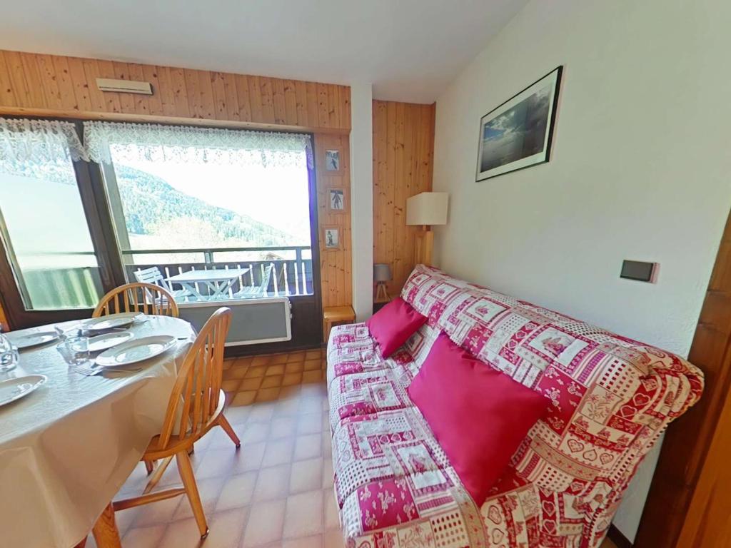 un salon avec un canapé et une table dans l'établissement Appartement cosy 5 couchages avec balcon, navette au pied, garage et ménage inclus - Le Grand-Bornand - FR-1-241-198, au Grand-Bornand