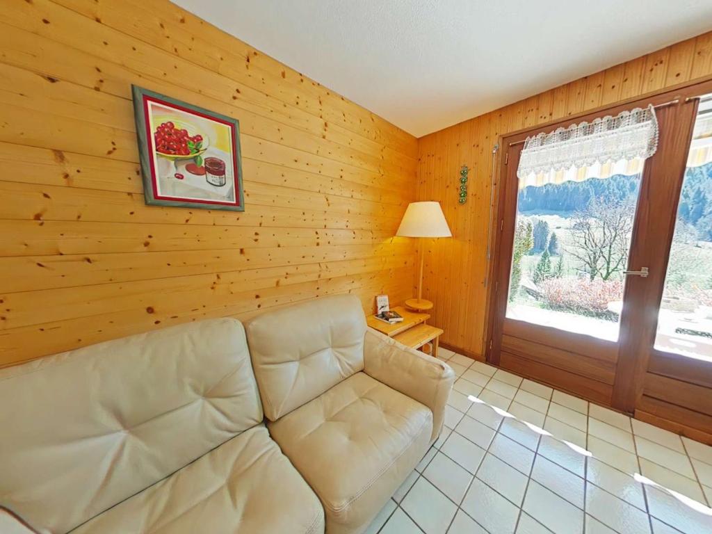 un salon avec un canapé et une fenêtre dans l'établissement Grand-Bornand : Appt 2 pièces, 4 pers, jardin, garage, à 900m des pistes - FR-1-241-91, au Grand-Bornand