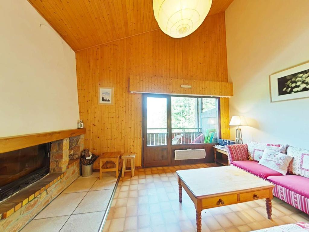 un salon avec un canapé et une cheminée dans l'établissement Appt 3 pièces, 7 pers, cheminée, garage, proche pistes - FR-1-241-50, au Grand-Bornand