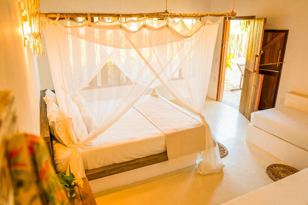 a bedroom with a bed with a canopy at Vila Vento in Atins
