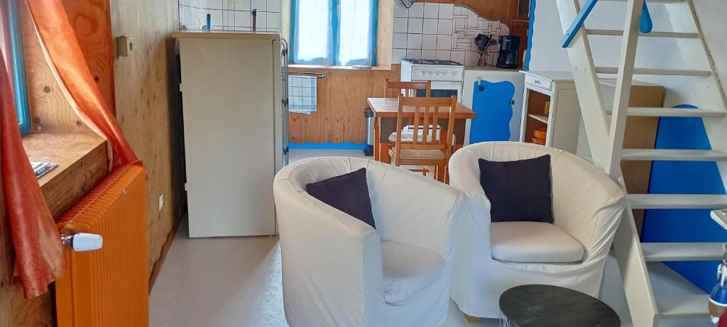 salon z 2 krzesłami i drabiną w obiekcie Gîte 2 personnes 700m de la plage w mieście Trévou-Tréguignec
