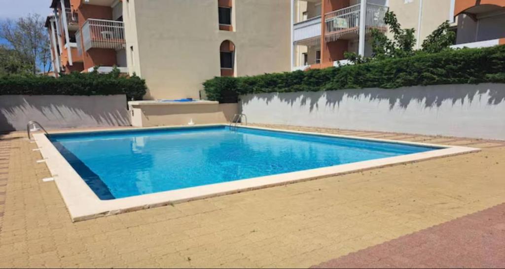 une piscine devant un immeuble dans l'établissement Résidence primavera cap d agde, au Cap d'Agde