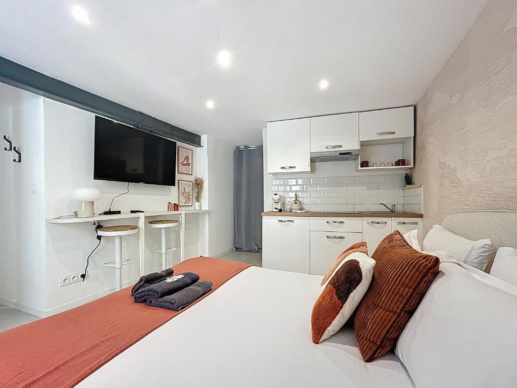 une chambre avec un grand lit blanc et une cuisine dans l'établissement Magnifique appartement - Quartier typique Panier - Les Frères de la Loc', à Marseille