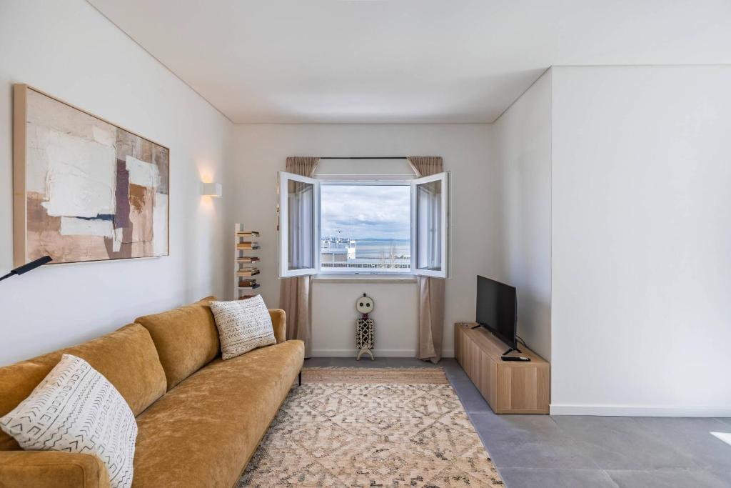 Una sala de estar con un sofá y un televisor. en 176 - Charming Riverview Apartment, en Oeiras