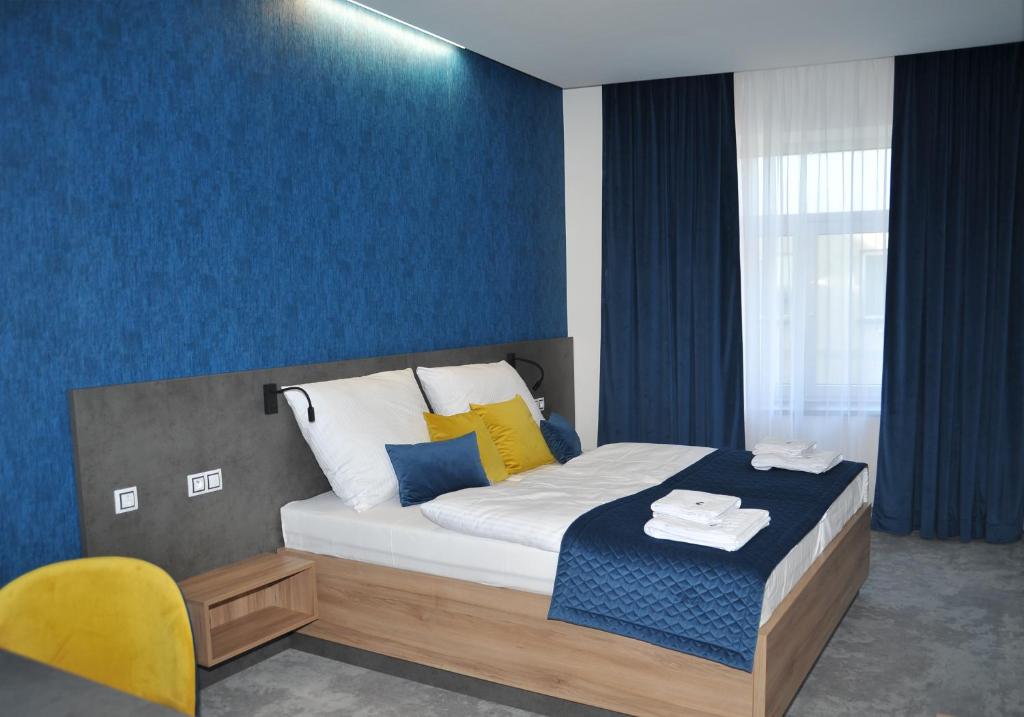 a bedroom with a bed with a blue wall at HRADBY hotel a restaurace in Uničov