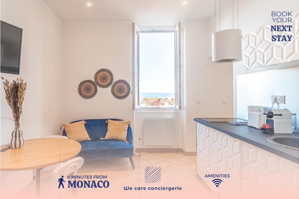 eine Küche mit einem Tisch und einem blauen Sofa in einem Zimmer in der Unterkunft T2 Town Center, Casino in Beausoleil