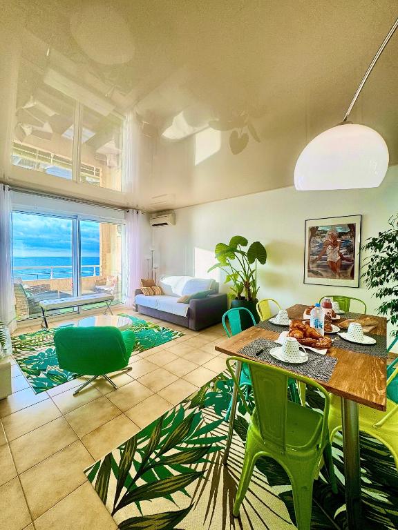 - un salon avec une table et des chaises vertes dans l'établissement Vue exceptionnelle début Cap Corse La Pier Noire, à San-Martino-di-Lota