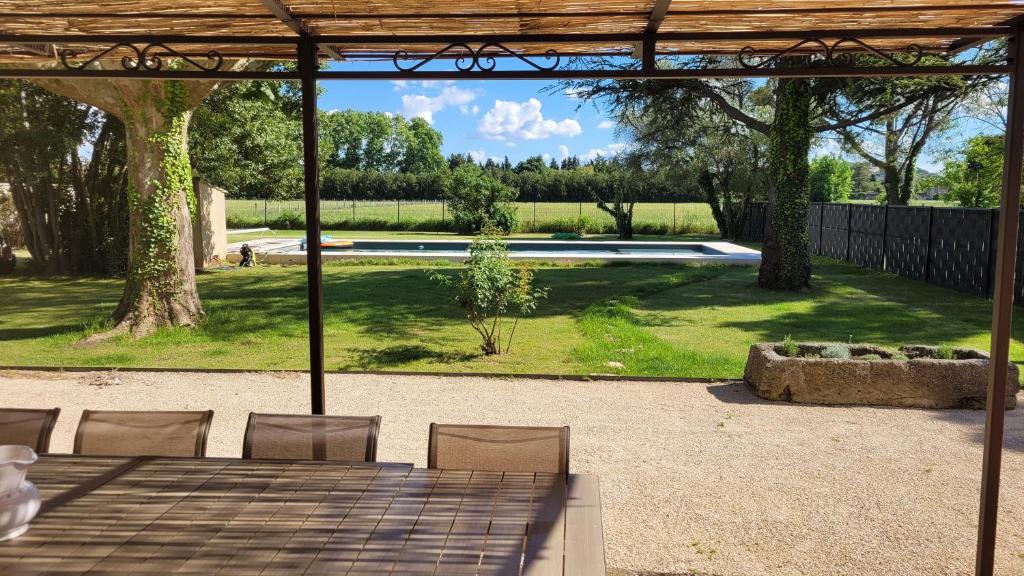 Elle offre une vue sur une terrasse avec une table et des chaises. dans l'établissement Villa paisible en Provence, à Orange