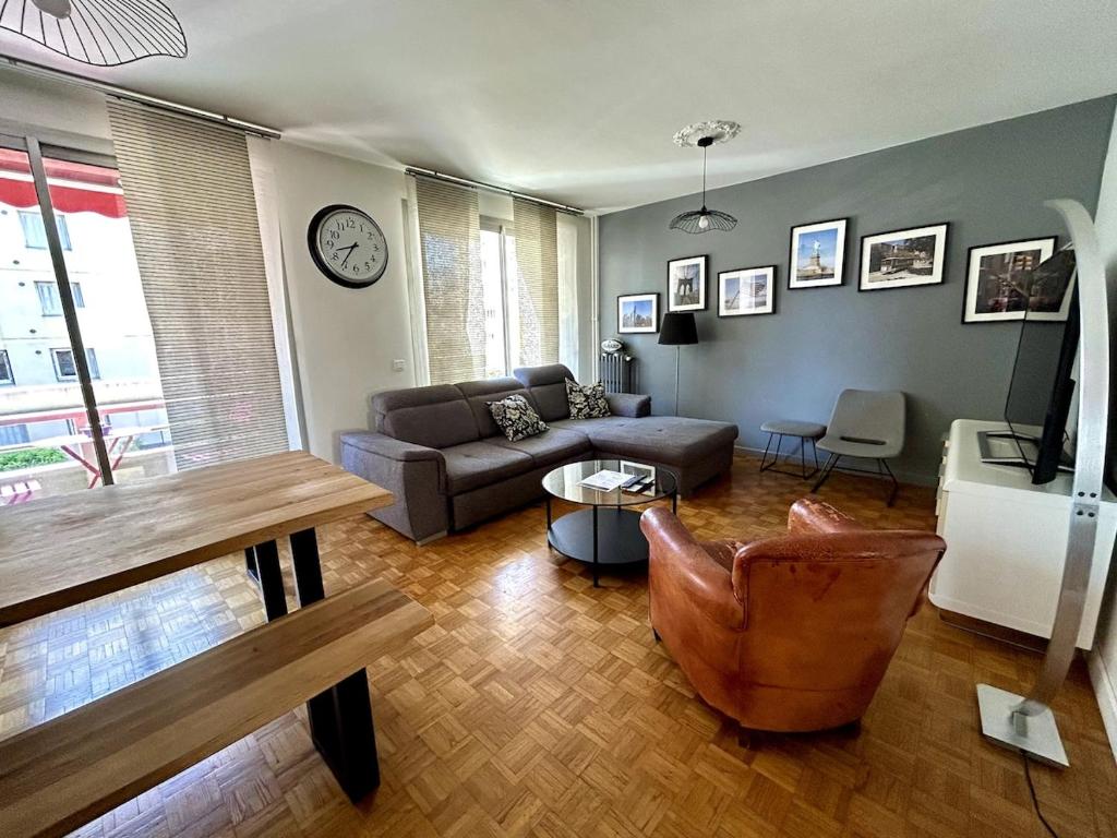 un salon avec un canapé et une table dans l'établissement Tony Garnier 2 bedrooms - balcony - parking, à Lyon