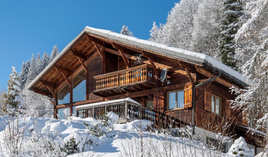 une cabane en rondins dans la neige dans l'établissement Chalet Mélèze, aux Gets