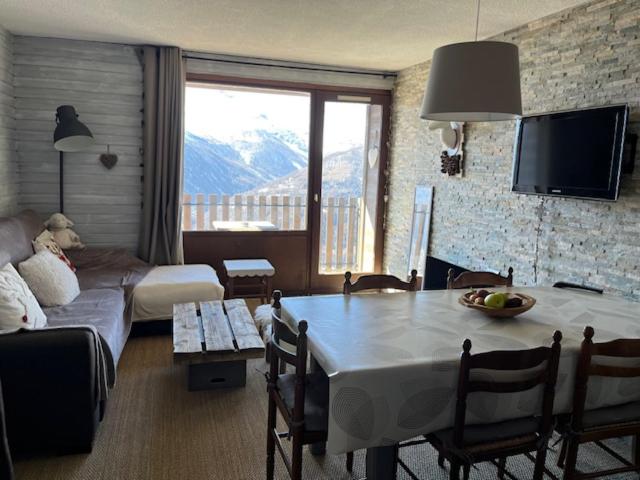 - un salon avec une table et un canapé dans l'établissement Appart cosy, à Orcières