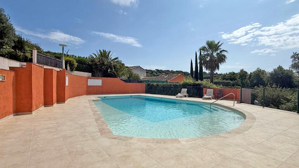 - une piscine avec deux chaises dans la cour dans l'établissement Val Oréa 3, à Sainte-Maxime