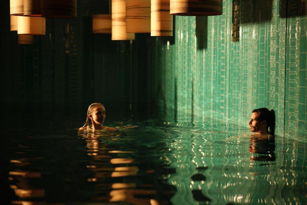 two people are swimming in a swimming pool at El Llorenc Parc de la Mar - Adults Only (+16) in Palma de Mallorca