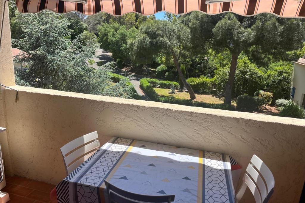 d'une table et de chaises sur un balcon avec vue sur les arbres. dans l'établissement Appartement avec balcon proche du Port de Santa Lucia, à Saint-Raphaël